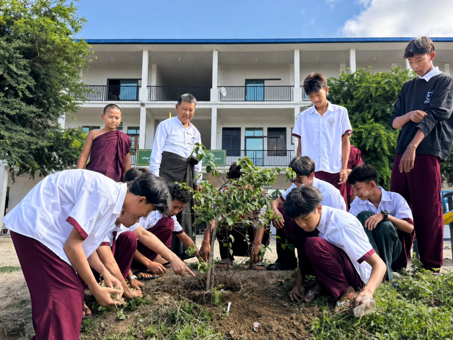 IBEC students and teachers planting a tree together